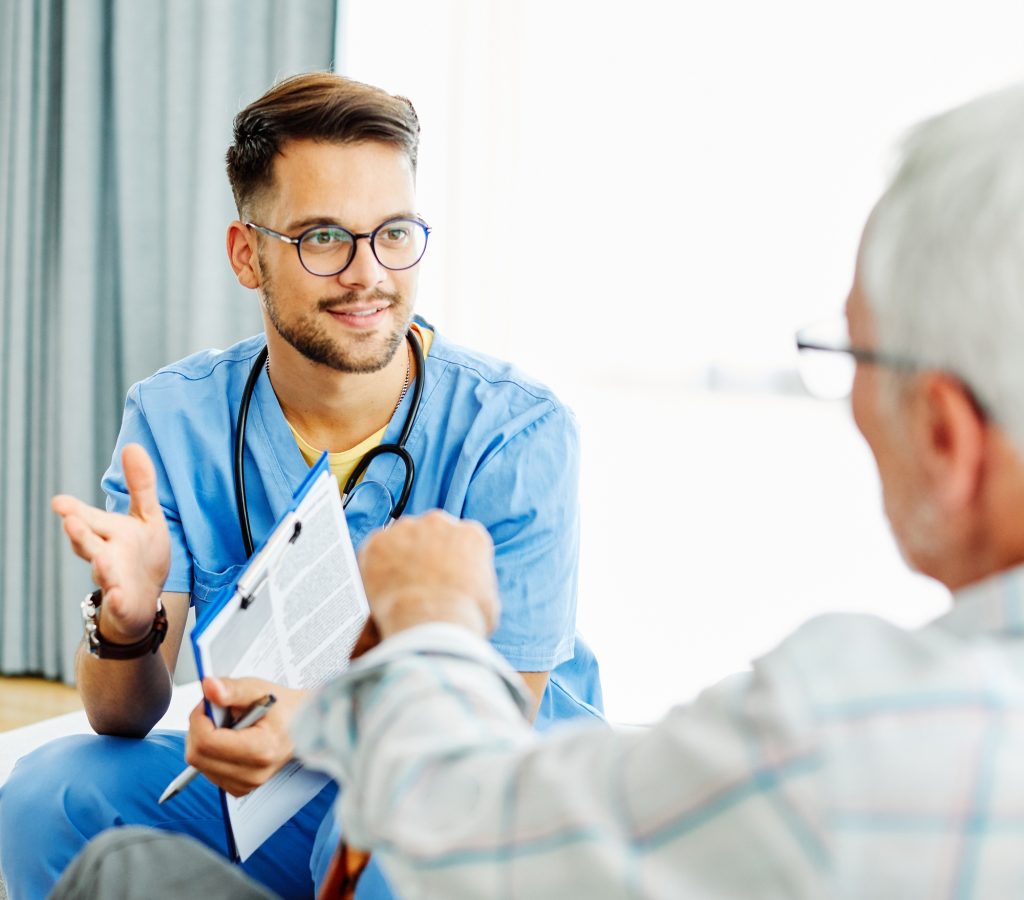 A Toronto dementia care nurse holding a clip board talking to a home care patient