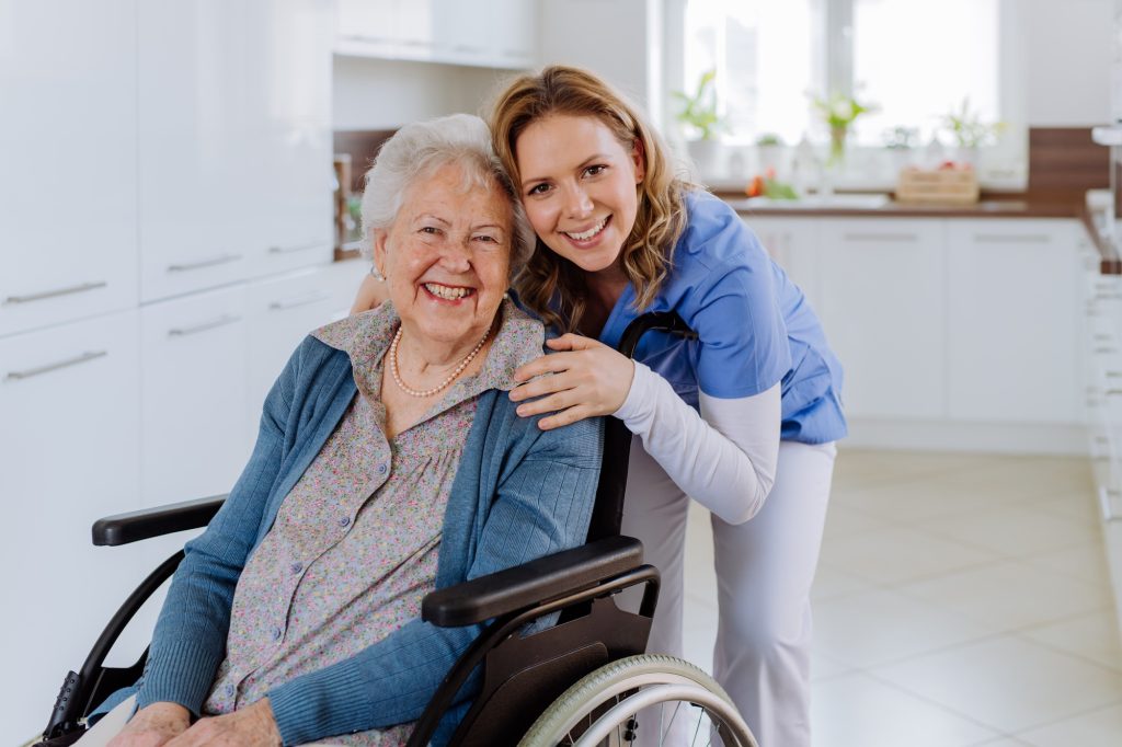 Portrait of nurse from a dementia care agency in Toronto and her senior client on a wheelchair smiling